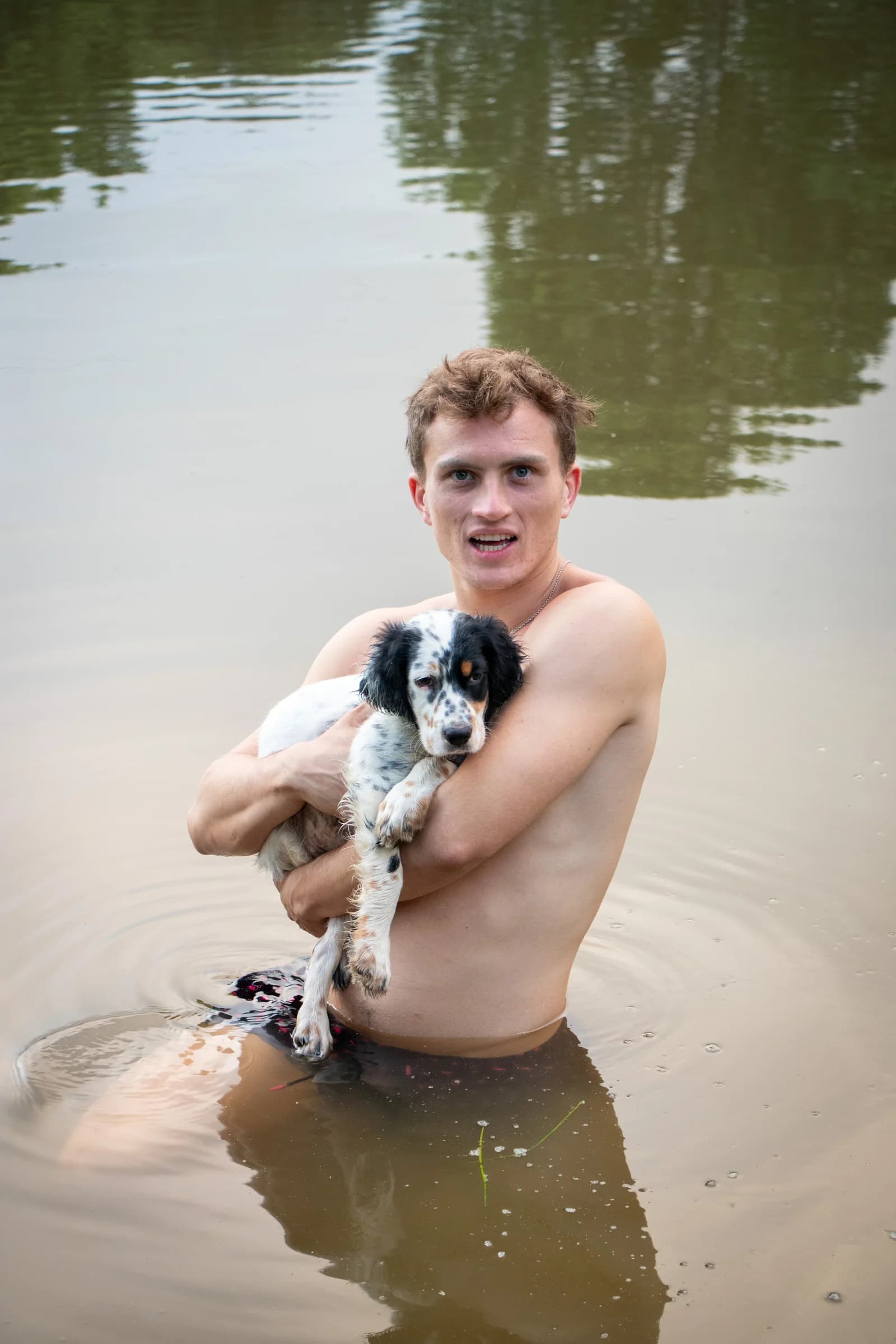 Cameron standing in water with his dog